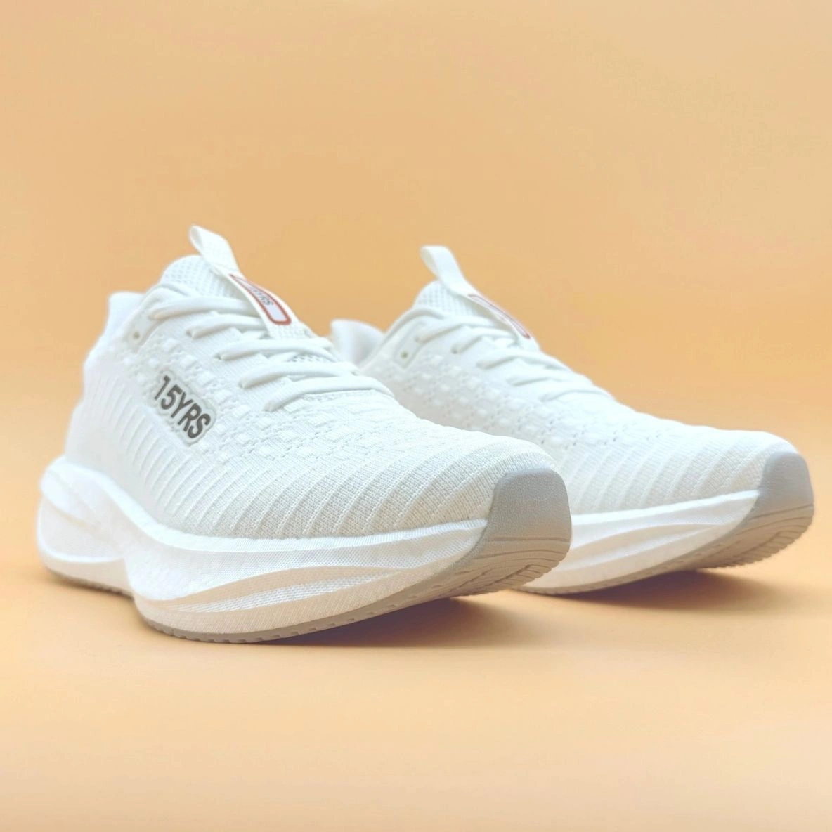 White athletic shoes on a beige background.