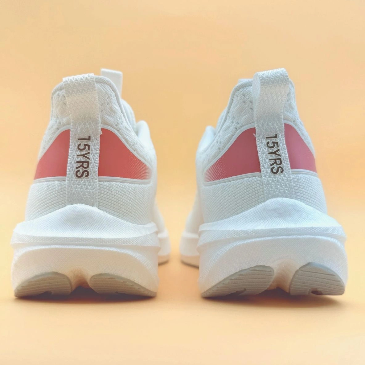 White sneakers with red accents, rear view.