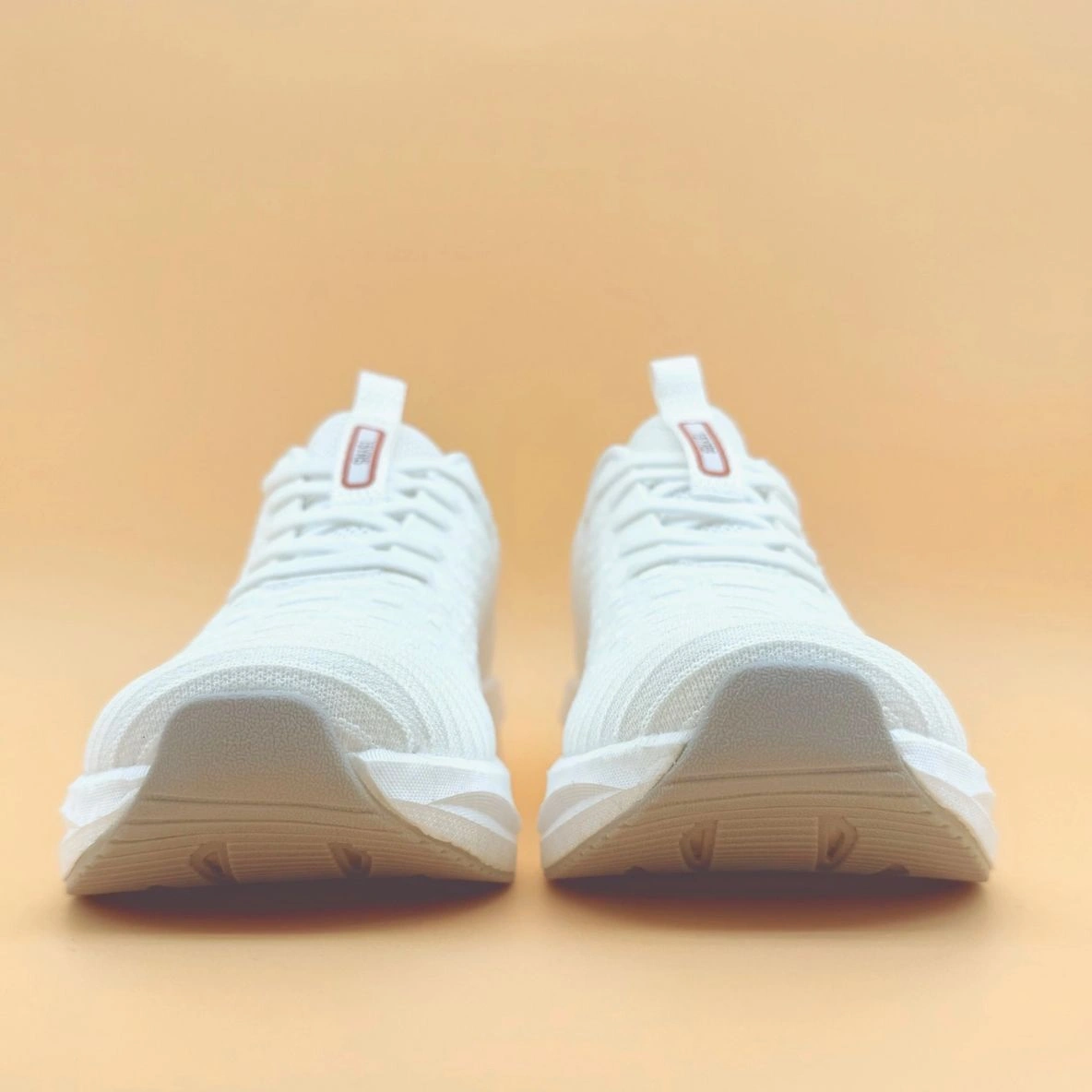 White sneakers on a beige background.