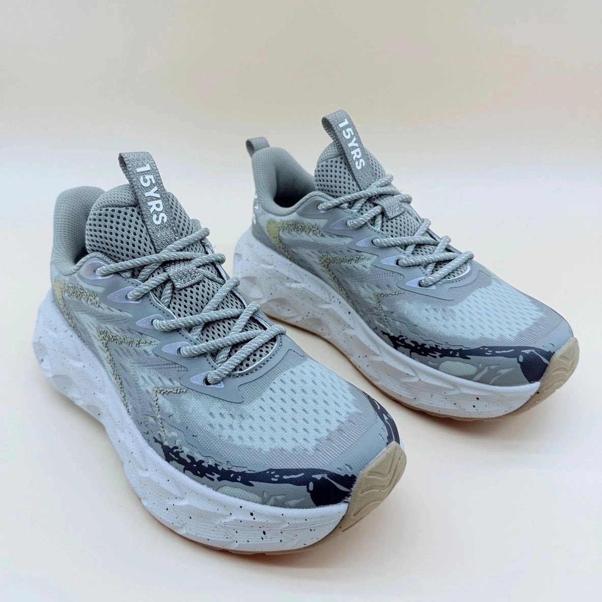 Gray athletic sneakers with thick white soles.