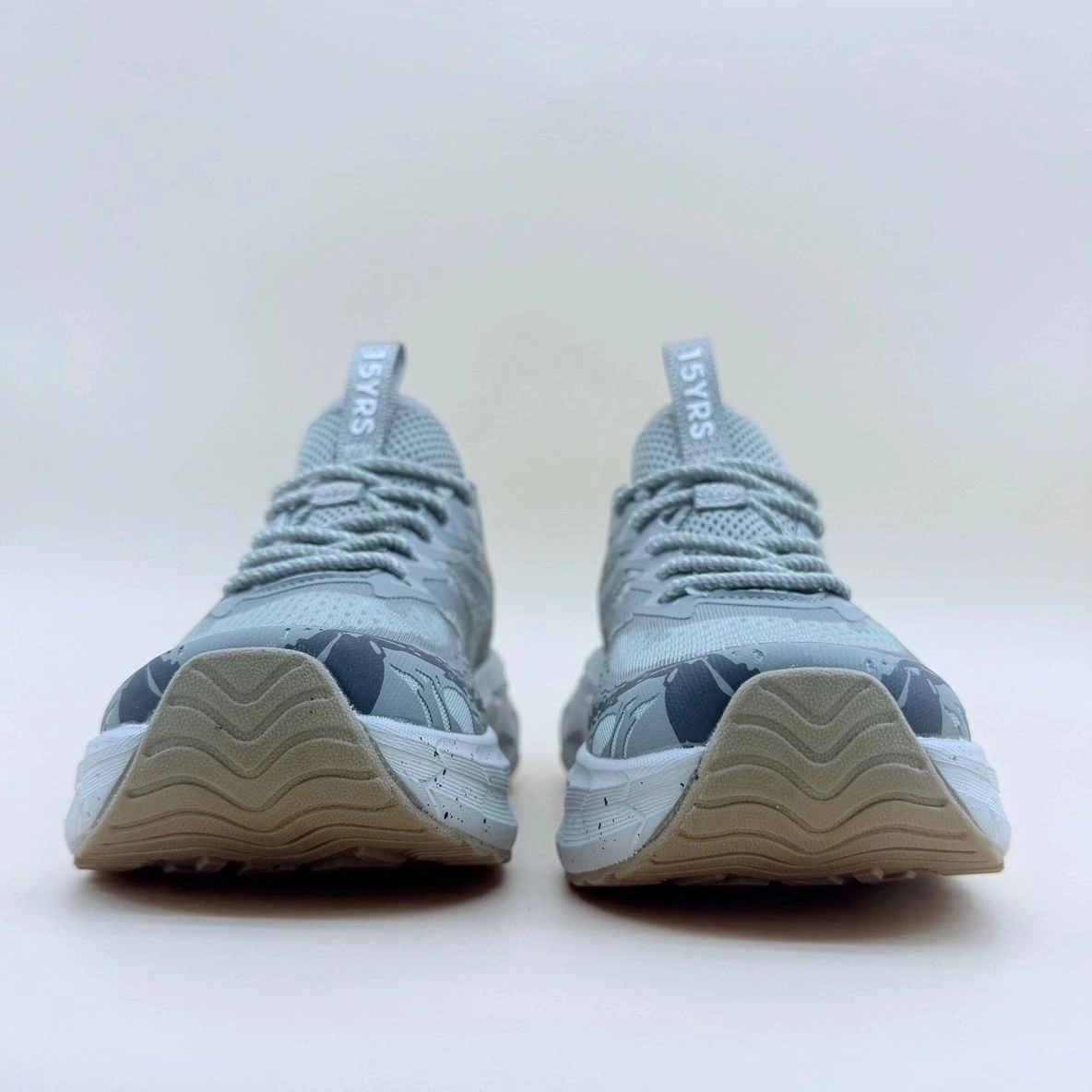 Gray athletic shoes with white soles.