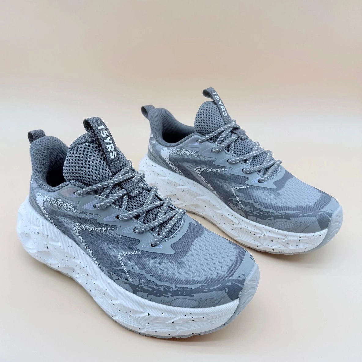 Gray athletic sneakers with white soles.