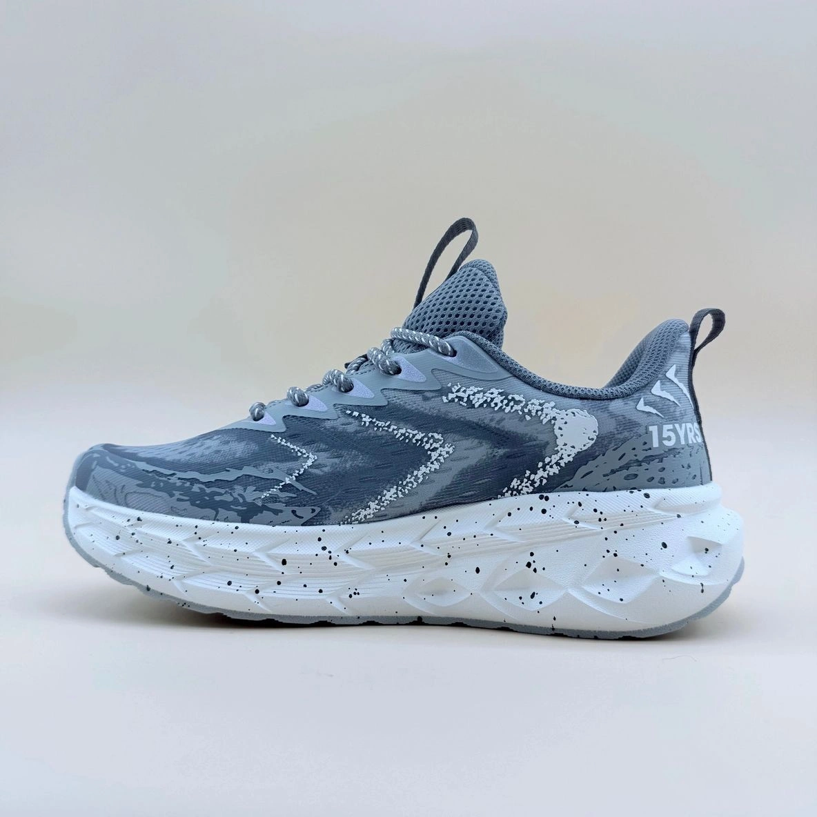 Gray and white athletic sneaker with pattern.